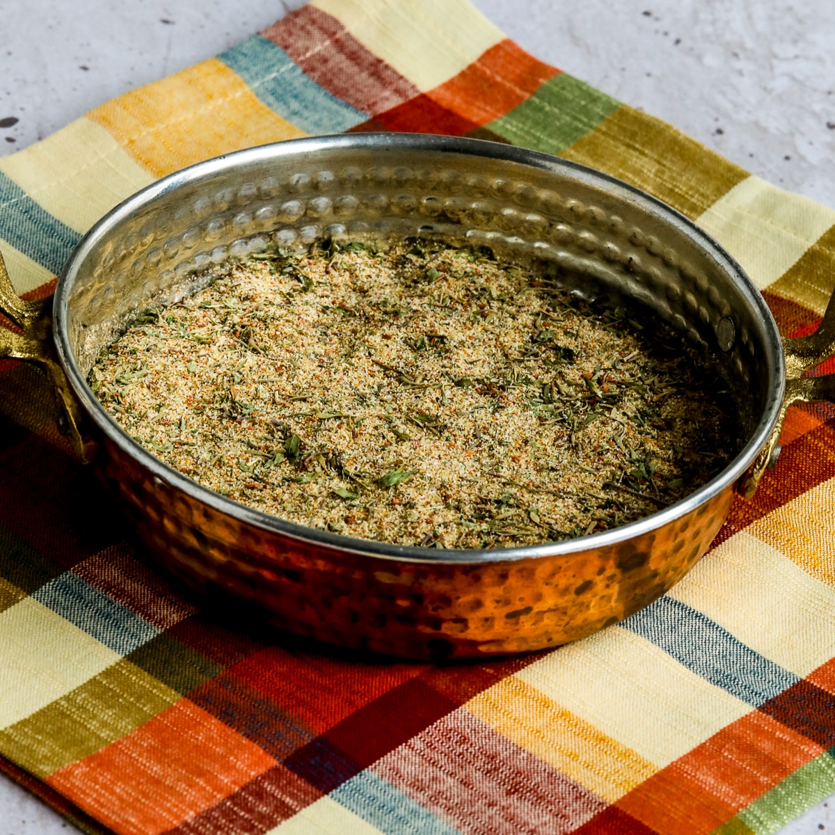 Square image for Chicken Seasoning Rub shown in copper bowl on napkin.