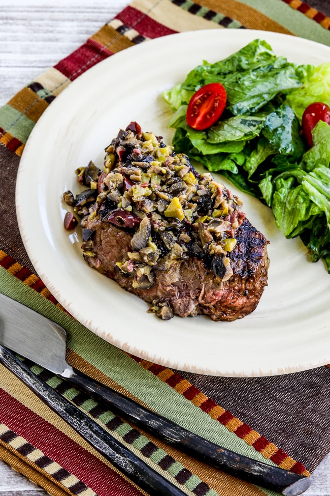 Pan-Grilled Steak with Olive Sauce photo of cooked steak with salad on serving plate