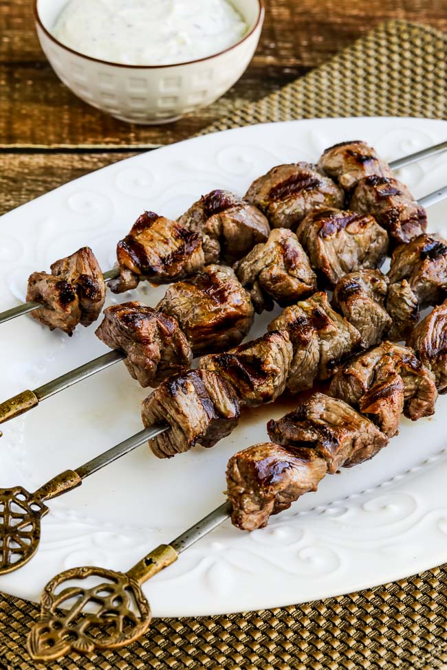 Greek Lamb Souvlaki shown on skewers on serving platter.