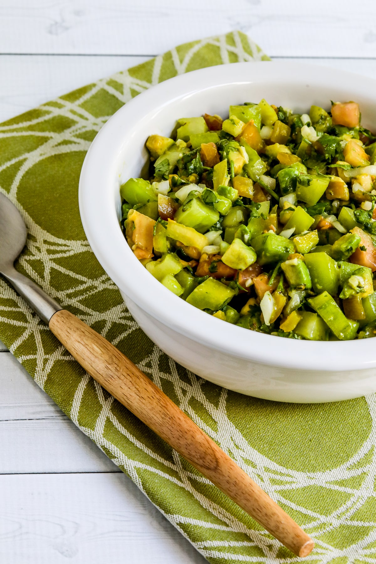 Green Tomato Salsa with Avocado shown in serving bowl with spoon.