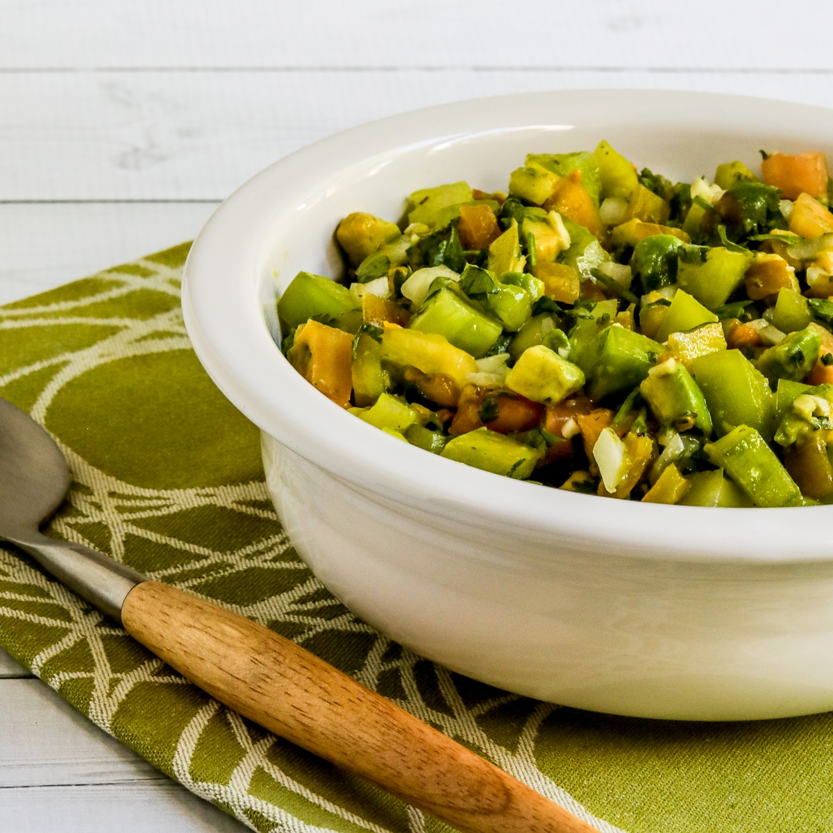 Green Tomato Salsa with Avocado shown in large serving bowl with serving spoon.