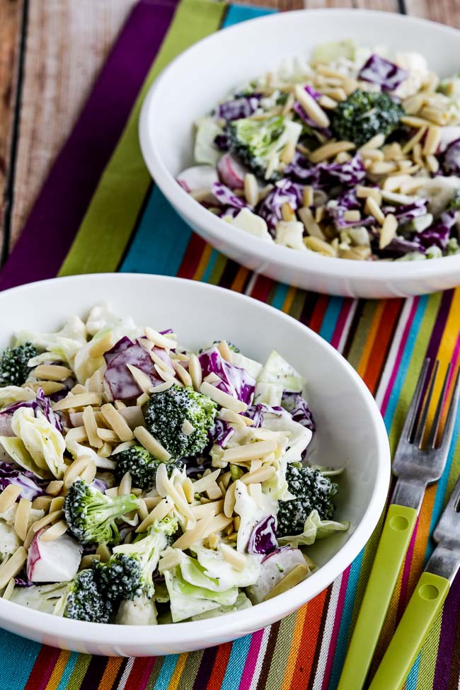 Keto Chopped Salad shown in two serving bowls with crunchy veggies and slivered almonds.