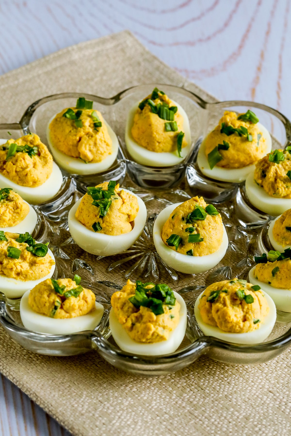 Spicy Deviled Eggs (with Chipotle and Lime) shown in glass egg dish.