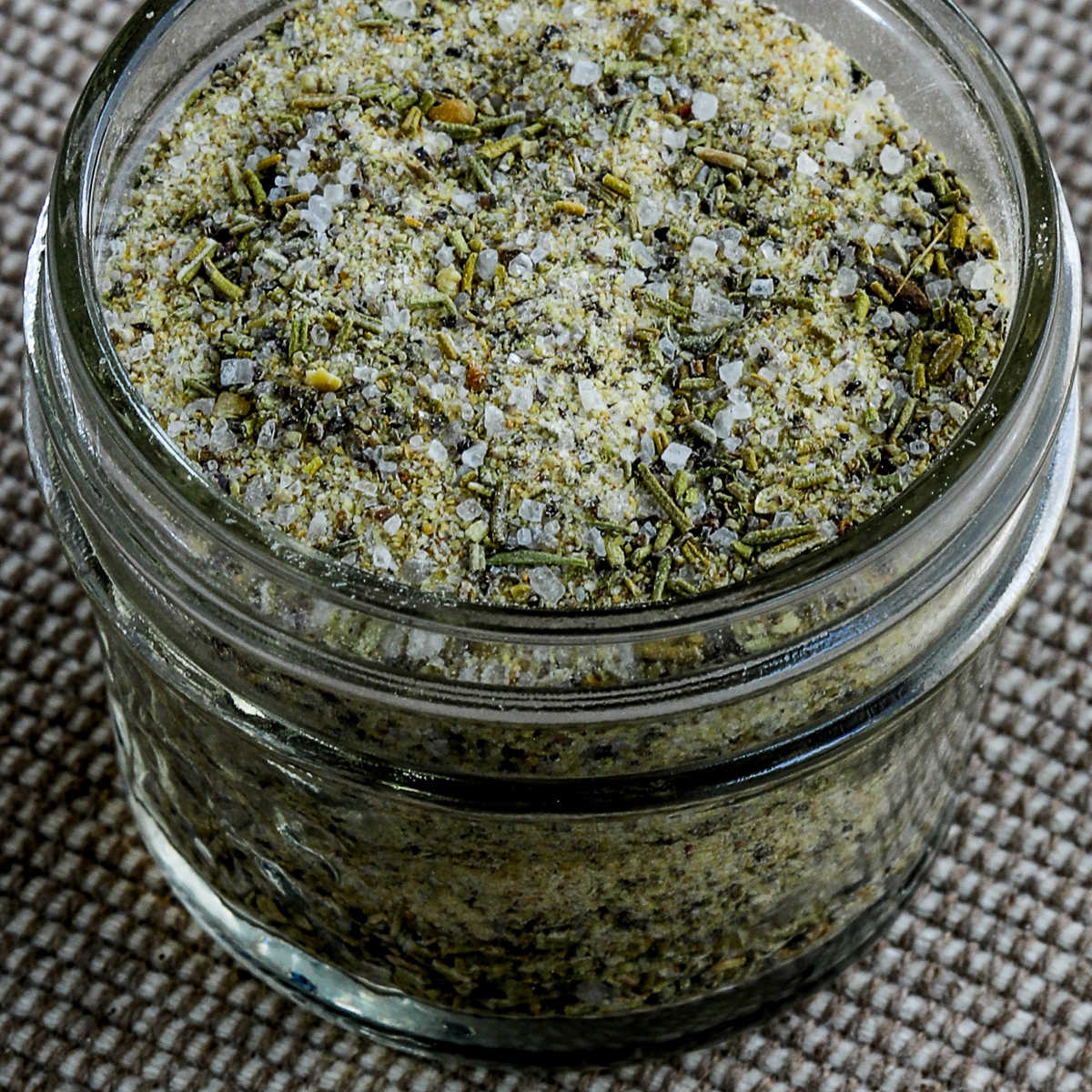 Square image for Rosemary Garlic Seasoning shown in open glass jar.