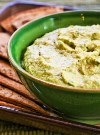 Parsley Hummus shown in serving bowl with low-carb pita bread.