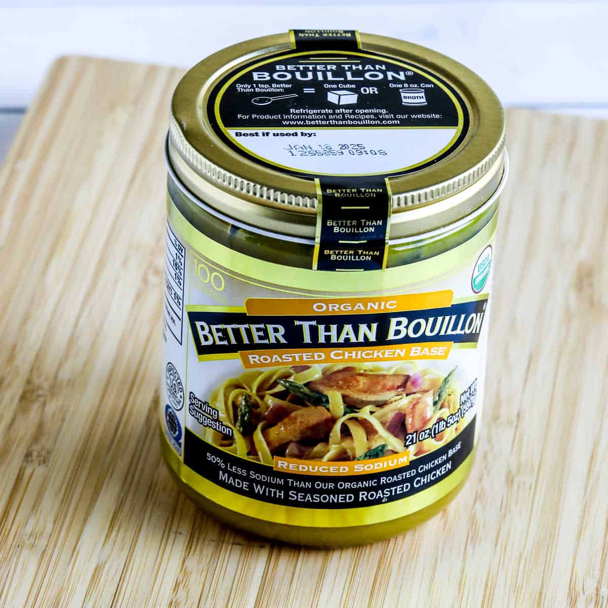 Square image of Better Than Bouillon Organic Roasted Chicken Base jar shown on cutting board.