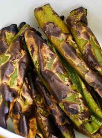 roasted green chiles with charred skin shown in bowl