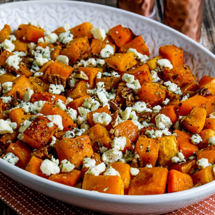 Roasted Butternut Squash with Rosemary, Pecans, and Gorgonzola shown on serving dish with salt-pepper in background