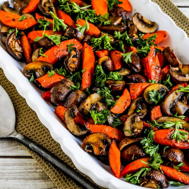 Roasted Carrots and Mushrooms shown on serving plate with parsley garnish