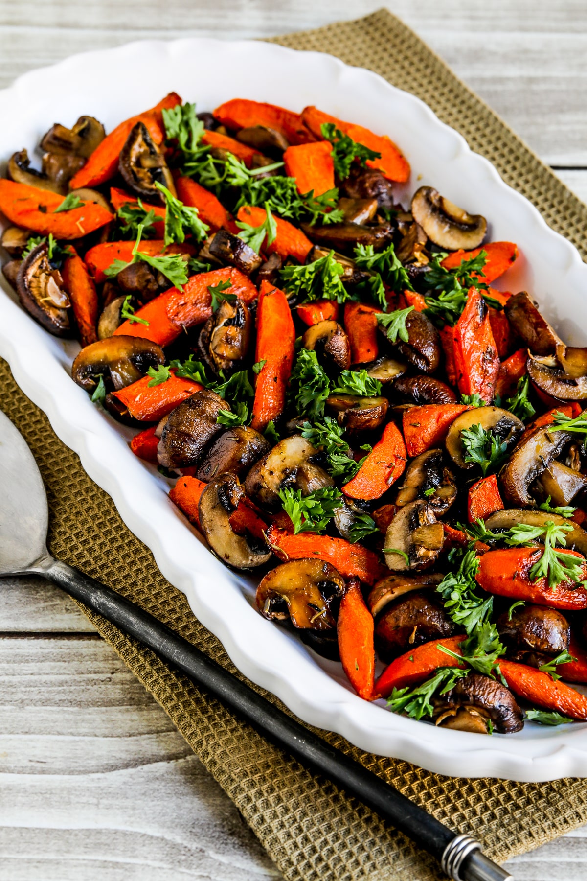 Roasted Carrots and Mushrooms shown on serving plate with parsley garnish