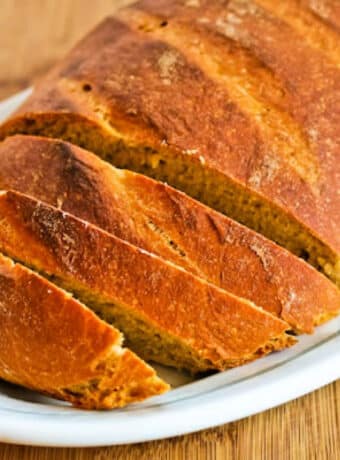 Square image of White Whole Wheat Bread with Olive Oil shown sliced on plate.