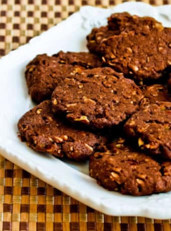 Square image for Sugar-Free Chocolate Pecan Cookies shown on white plate.