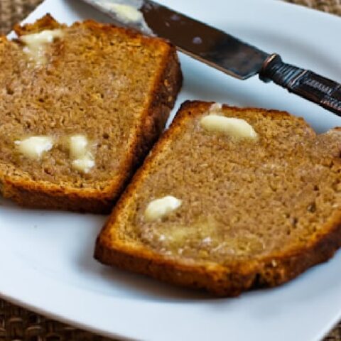 Brown Irish Soda Bread shown on serving plate with knife and butter melting