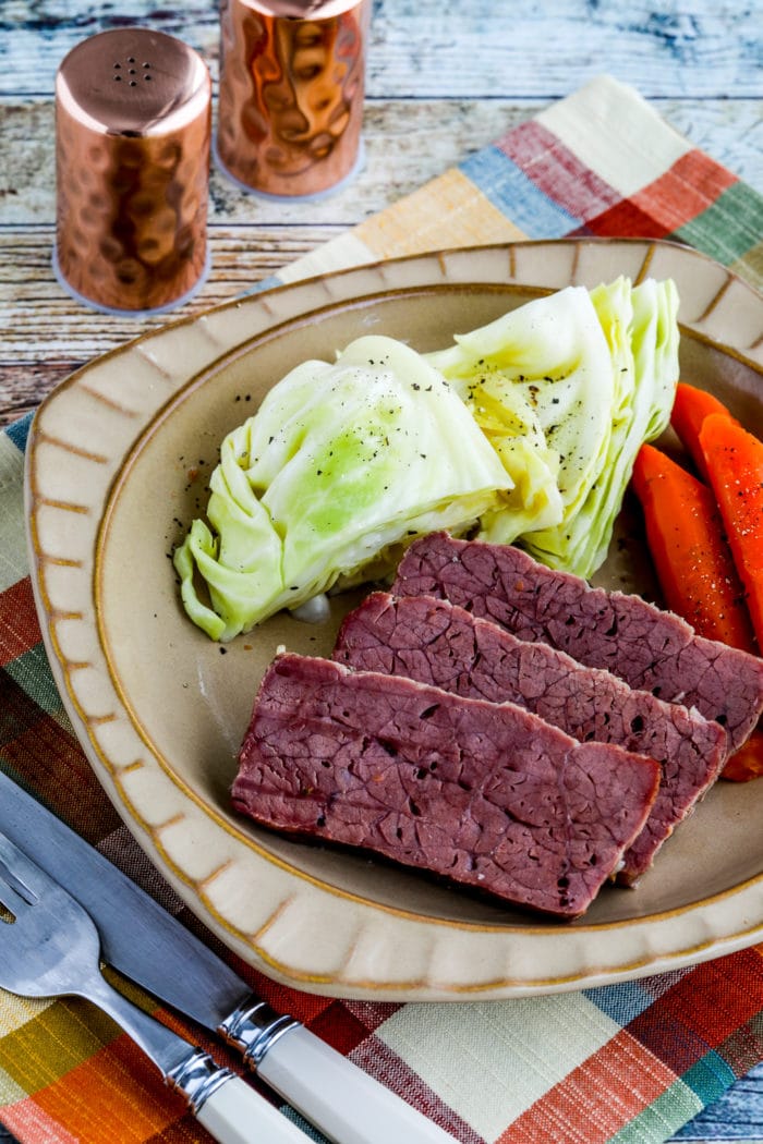 Slow Cooker Corned Beef close-up photo of corned beef on plate with vegetables
