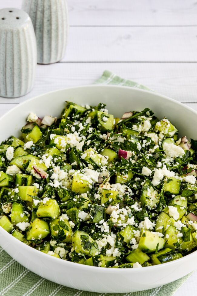 Cucumber salad with parsley and feta, close-up of ready-made salad in serving bowl