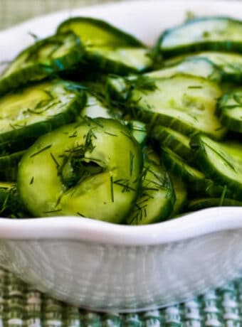 Sweet and Sour Cucumber Salad shown in serving bowl with dill