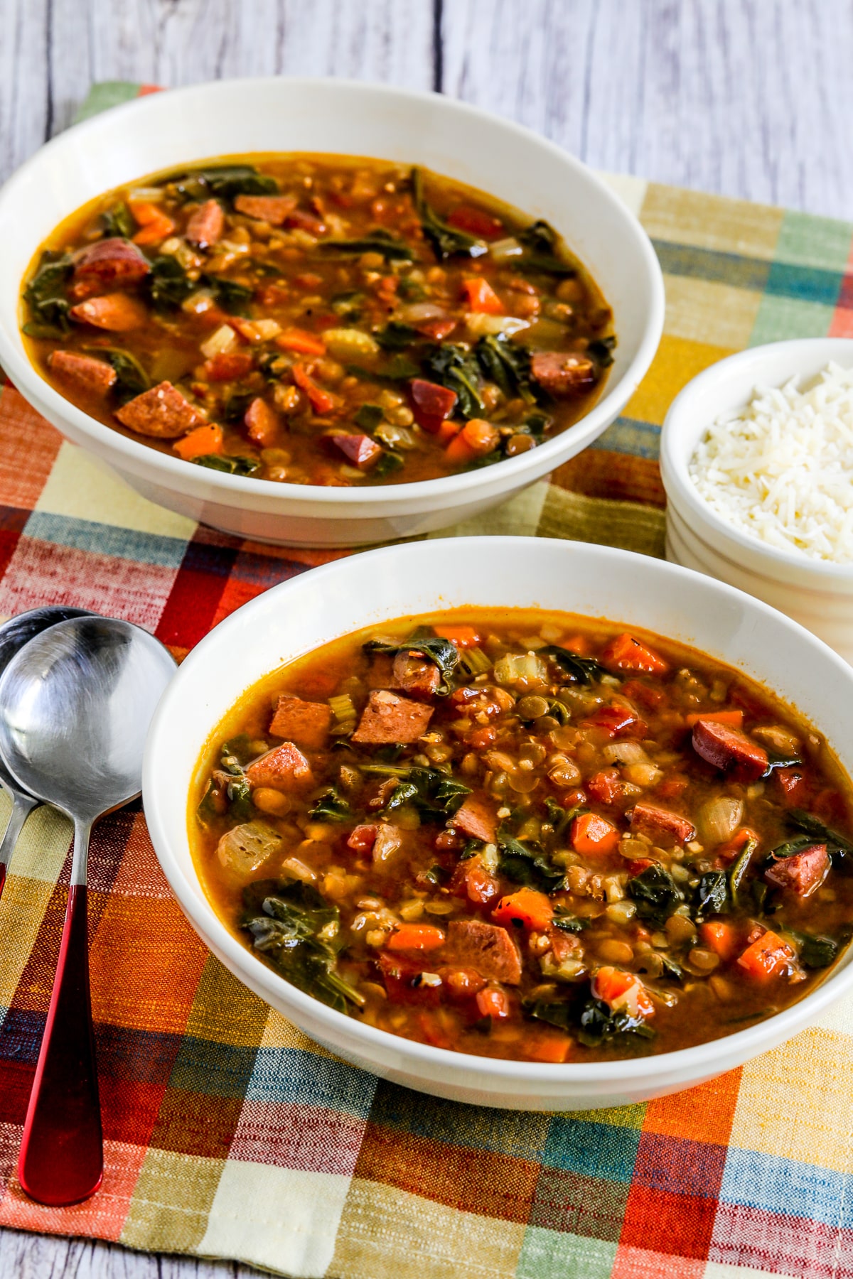 Lentil sausage soup with clarified spinach in two soup bowls