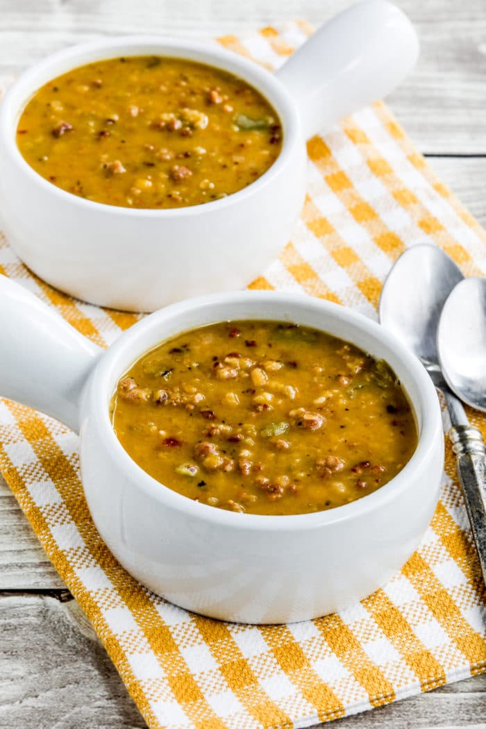 Yellow Split Pea Soup in white serving bowls with spoons, bowls closer together