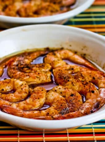 Spicy Broiled Shrimp Recipe shown in two gratin dishes.