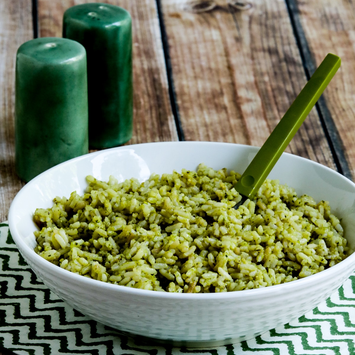 Square image for Lemon Pesto Rice Recipe showing rice in serving bowl on green-white napkin.