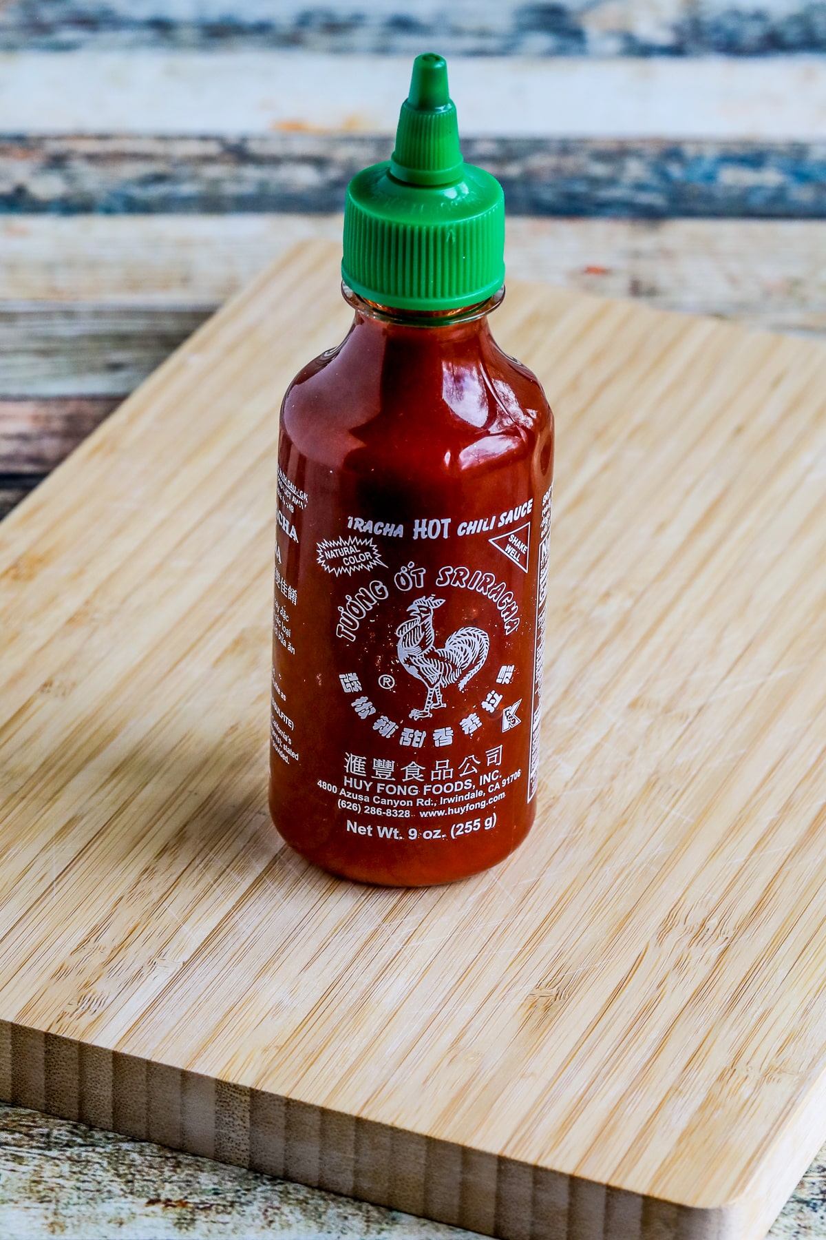 Sriracha Sauce bottle shown on cutting board.