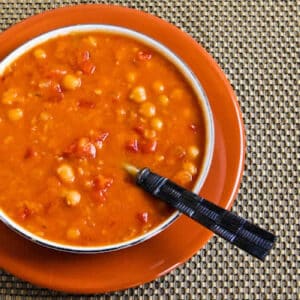 Square image for Red Lentil and Chickpea Soup shown in bowl on orange plate.