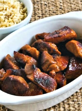 Square image of Filipino Pork Adobo in serving dish with rice.