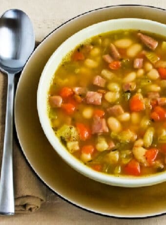 Square image of White Bean Soup with Ham shown in bowl with spoon.