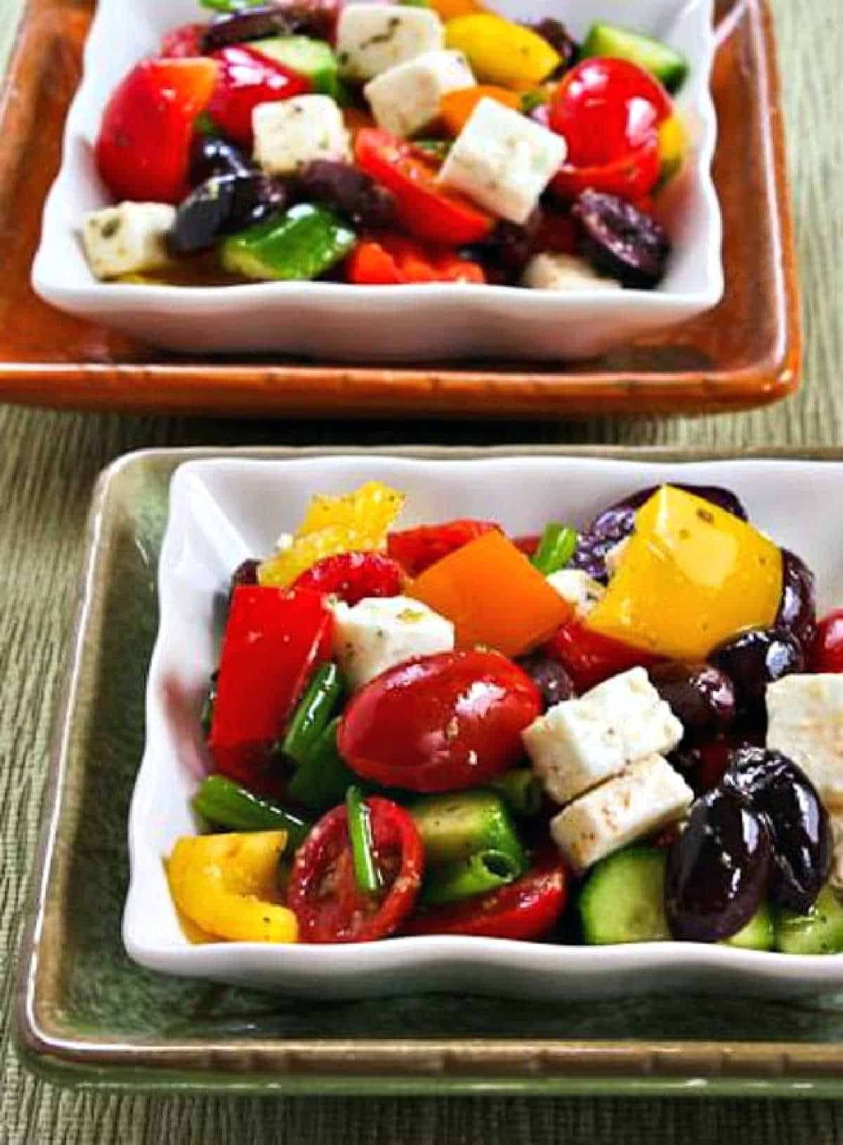 Chopped Greek Salad with Peppers shown in two stacked serving dishes