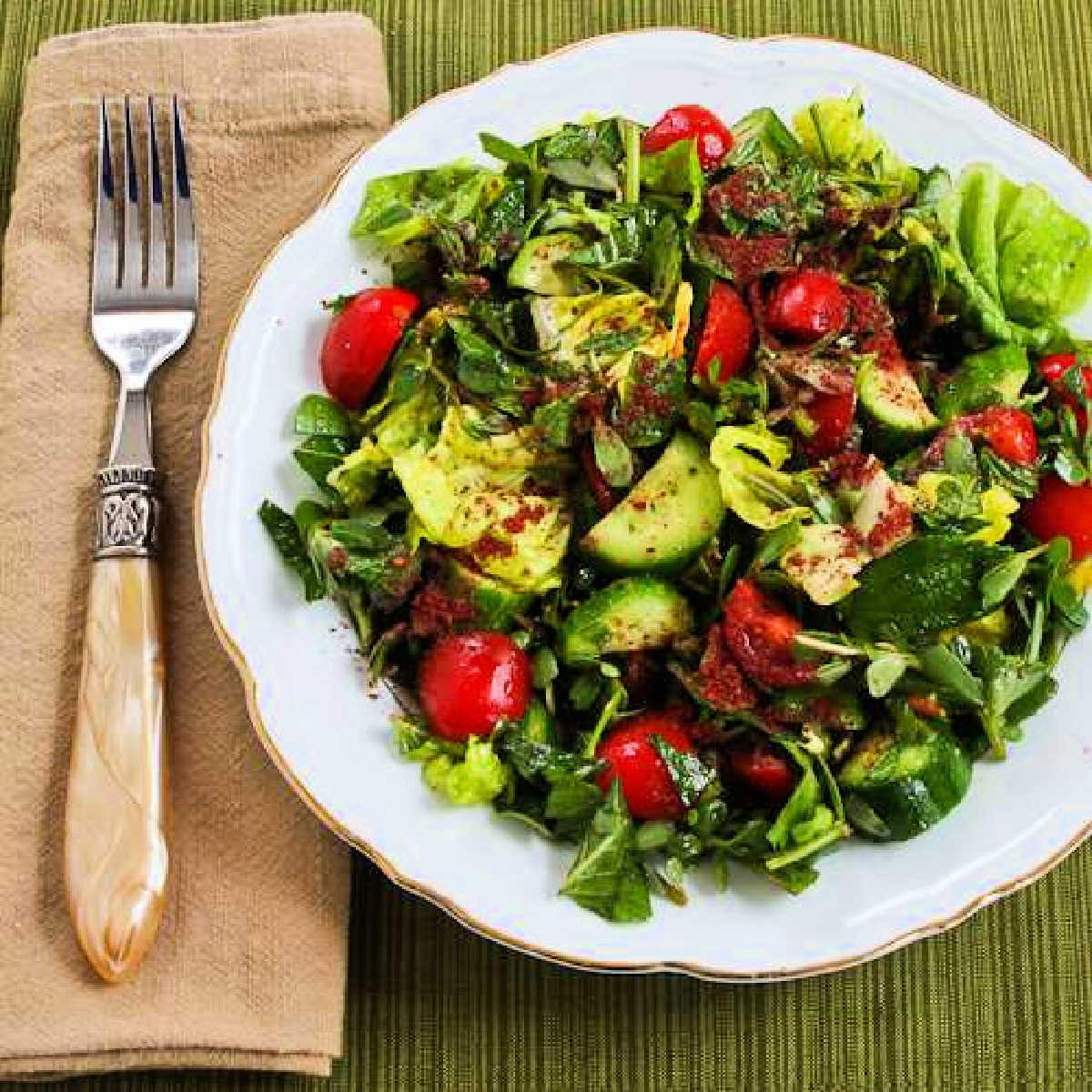 Purslane Salad with Lettuce, Tomatoes, Cucumbers, and Mint shown on salad plate with fork and napkin.