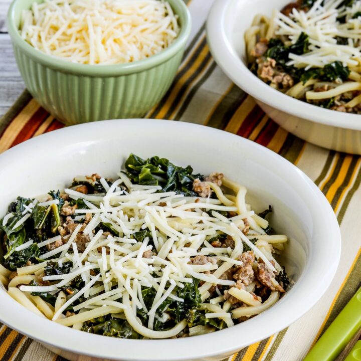 Pasta with Sausage and Kale finished dish shown in two serving bowls with Parmesan
