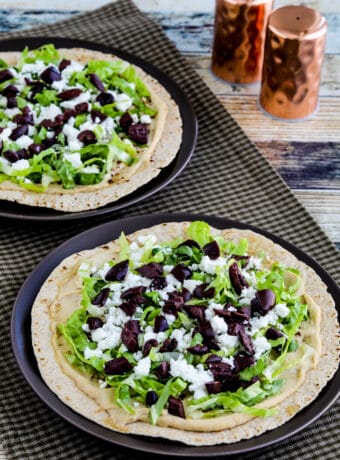 Middle Eastern Tostadas with Hummus and Feta shown on two serving plates with salt-pepper in background
