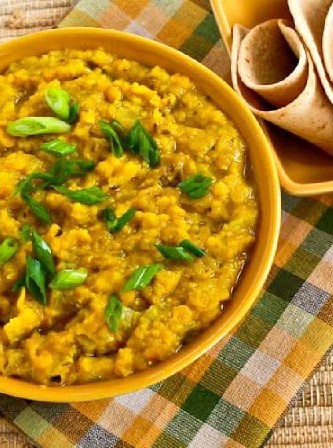 Red Lentil Dal shown in bowl with flatbread on side