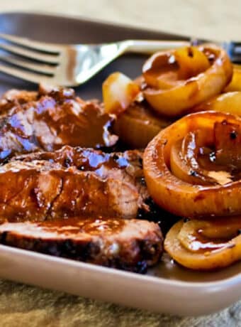 Square image for Slow Cooker Balsamic Pot Roast shown on plate with onions and sauce.