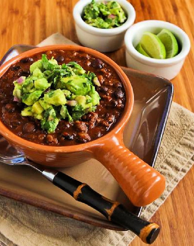 Black Bean and Beef Chili shown in crockery bowl with avocado salsa