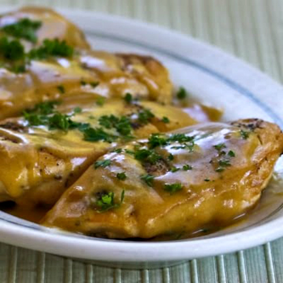 Mustard Chicken shown on serving platter with sauce and parsley garnish