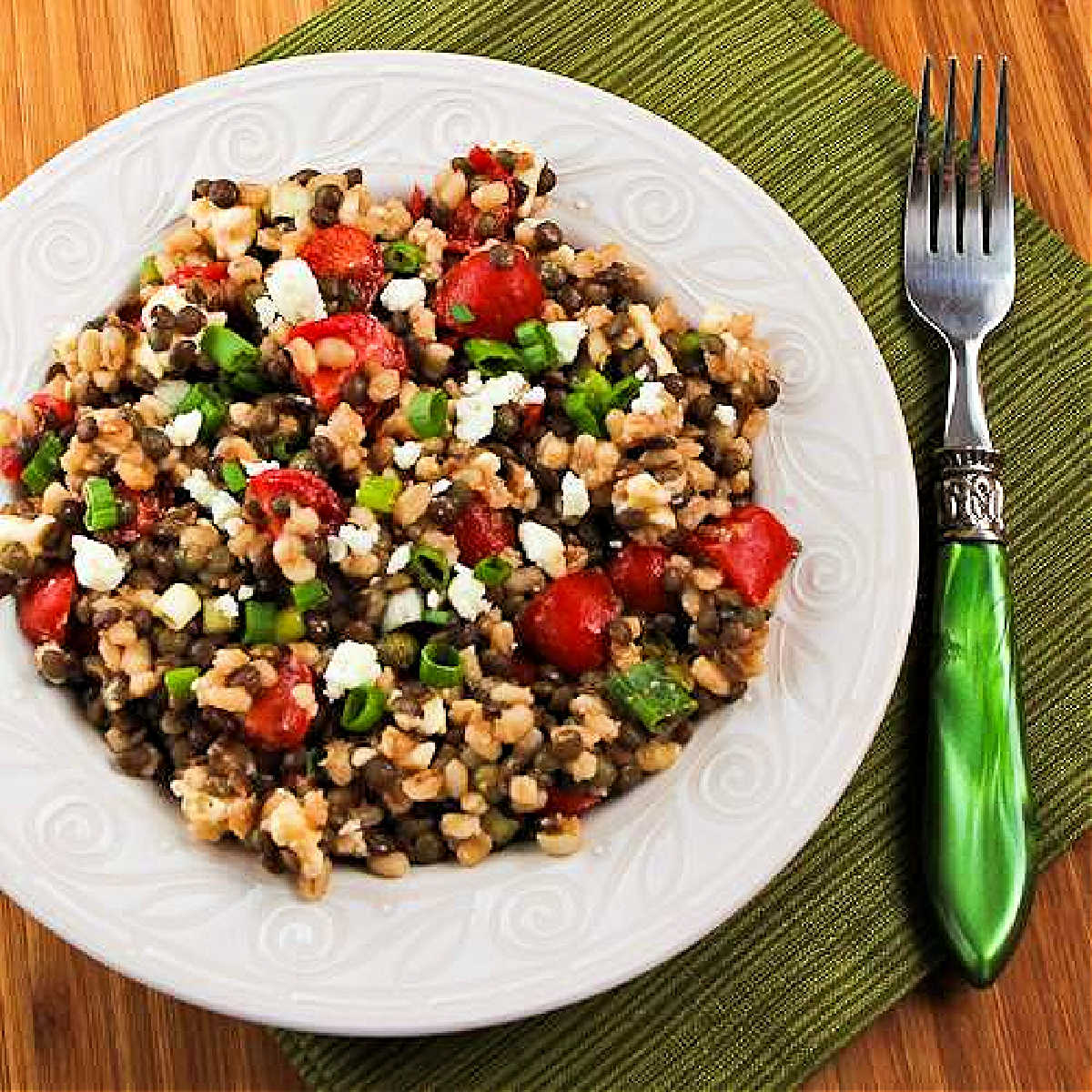 Square image for Lentil and Barley Greek-Style Salad shown on plate with fork.