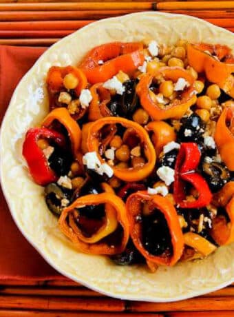 Square image for Marinated Bell Pepper Salad shown on serving plate with orange tray and napkin.
