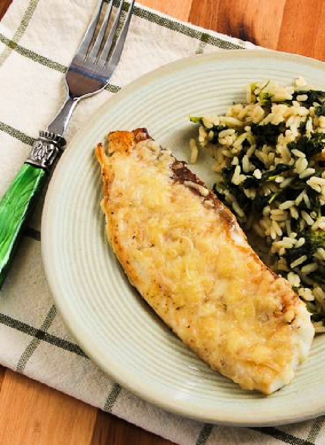 Cropped image of Parmesan Crusted Fish shown on serving plate with rice.