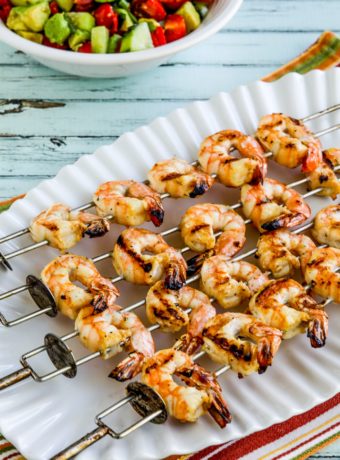 Grilled Shrimp Skewers on serving plate with bowl of tomato-avocado salsa.
