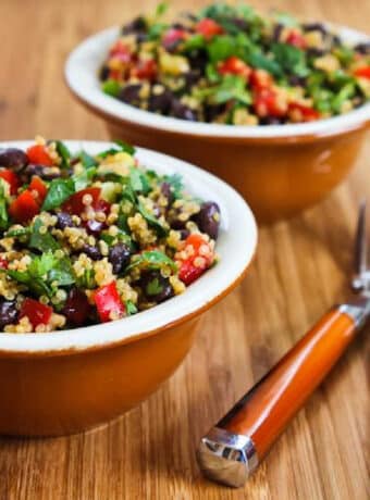 Southwestern Quinoa Salad shown in two serving bowls with forks
