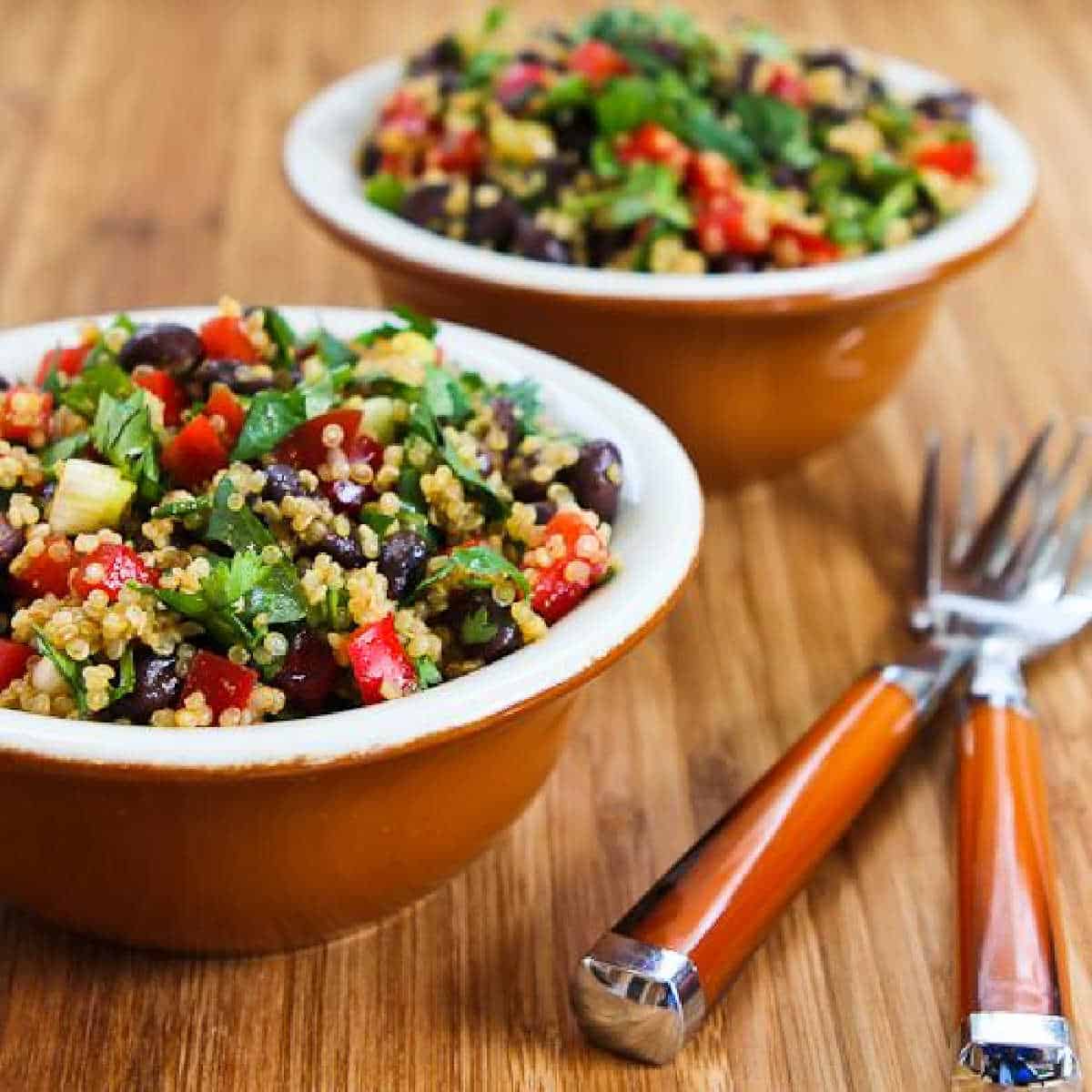 Southwestern quinoa salad served in two bowls with forks