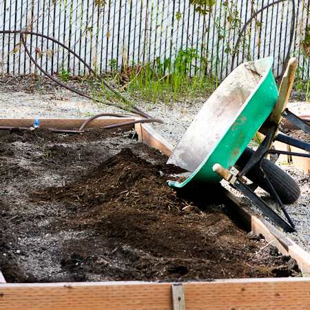 raised garden beds with organic material being added