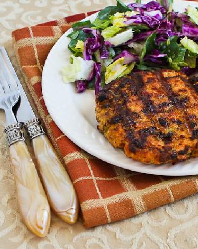 Grilled Salmon Burgers with Caper Mayo show on serving plate with salad