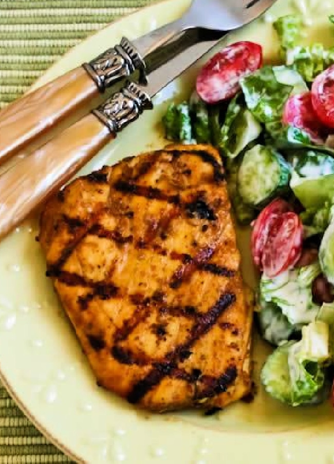 Marinated Grilled Halibut with Cumin and Lime shown on serving plate with salad.