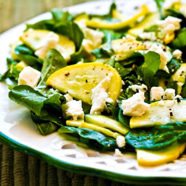 Raw summer squash salad with arugula and feta finished on a plate