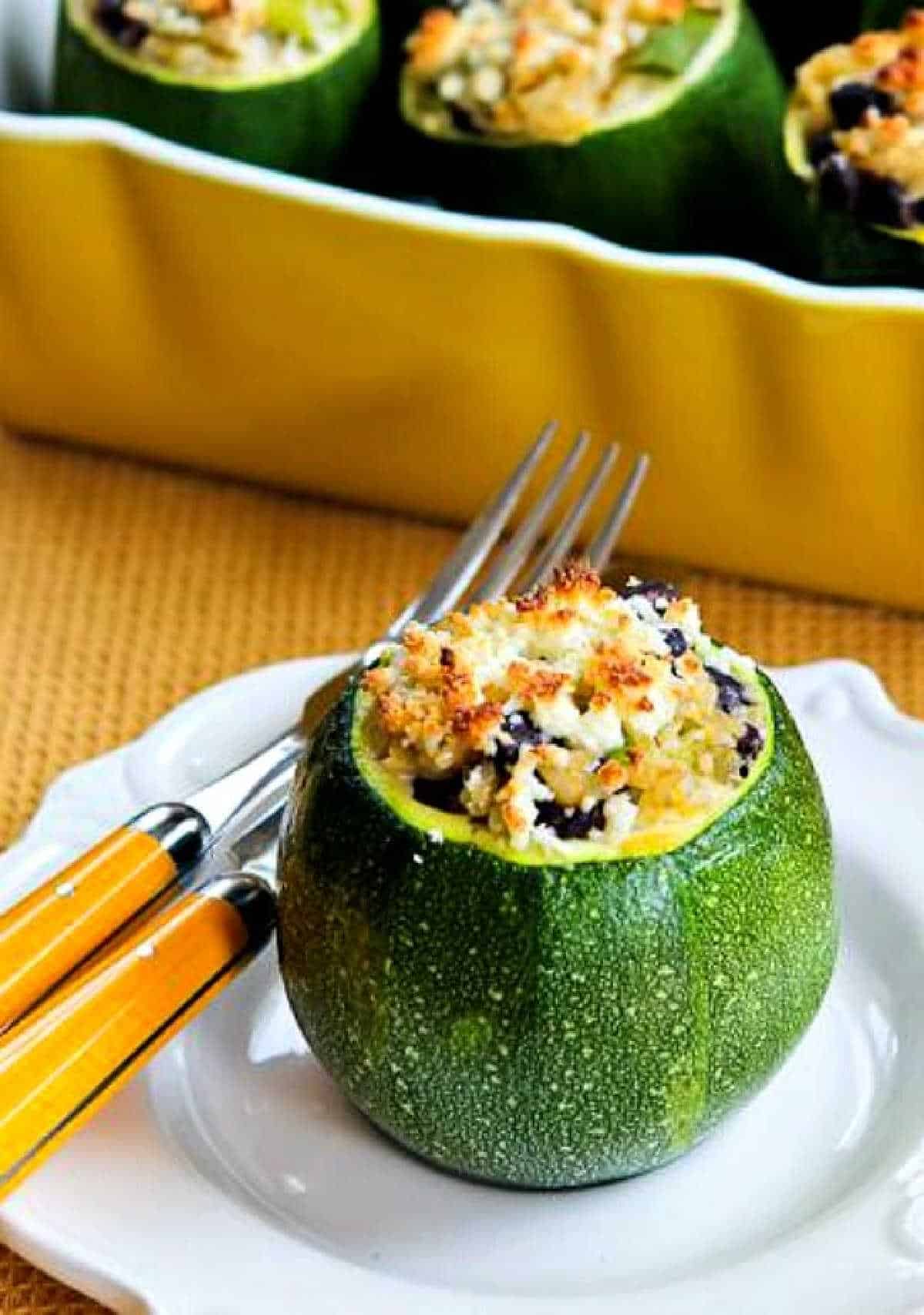 Vegetarian Stuffed Zucchini with one serving on plate and baking dish in background