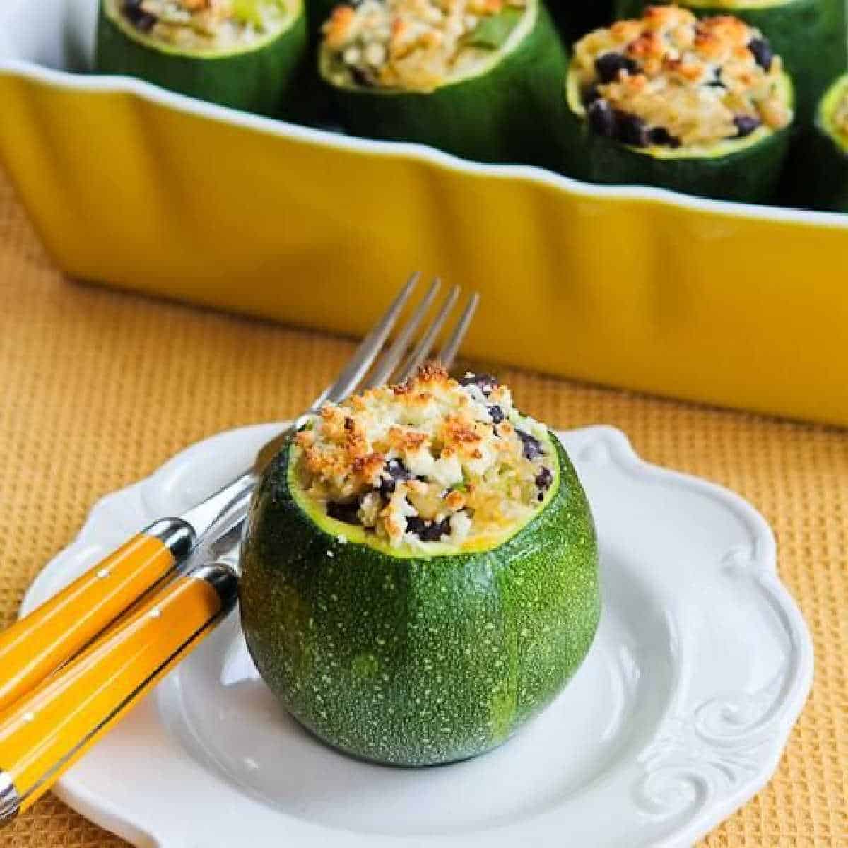 Vegetarian Stuffed Zucchini Shown on serving dish with cooking dish in background