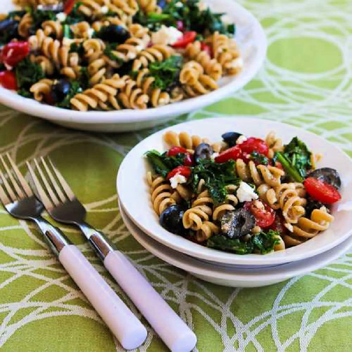 Kale Pasta Salad shown in two serving bowls with forks.