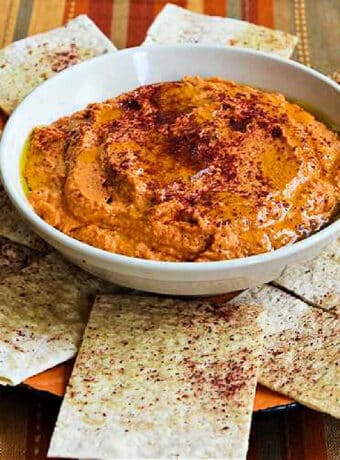 Square image for Roasted Tomato Hummus shown in bowl with pita bread.